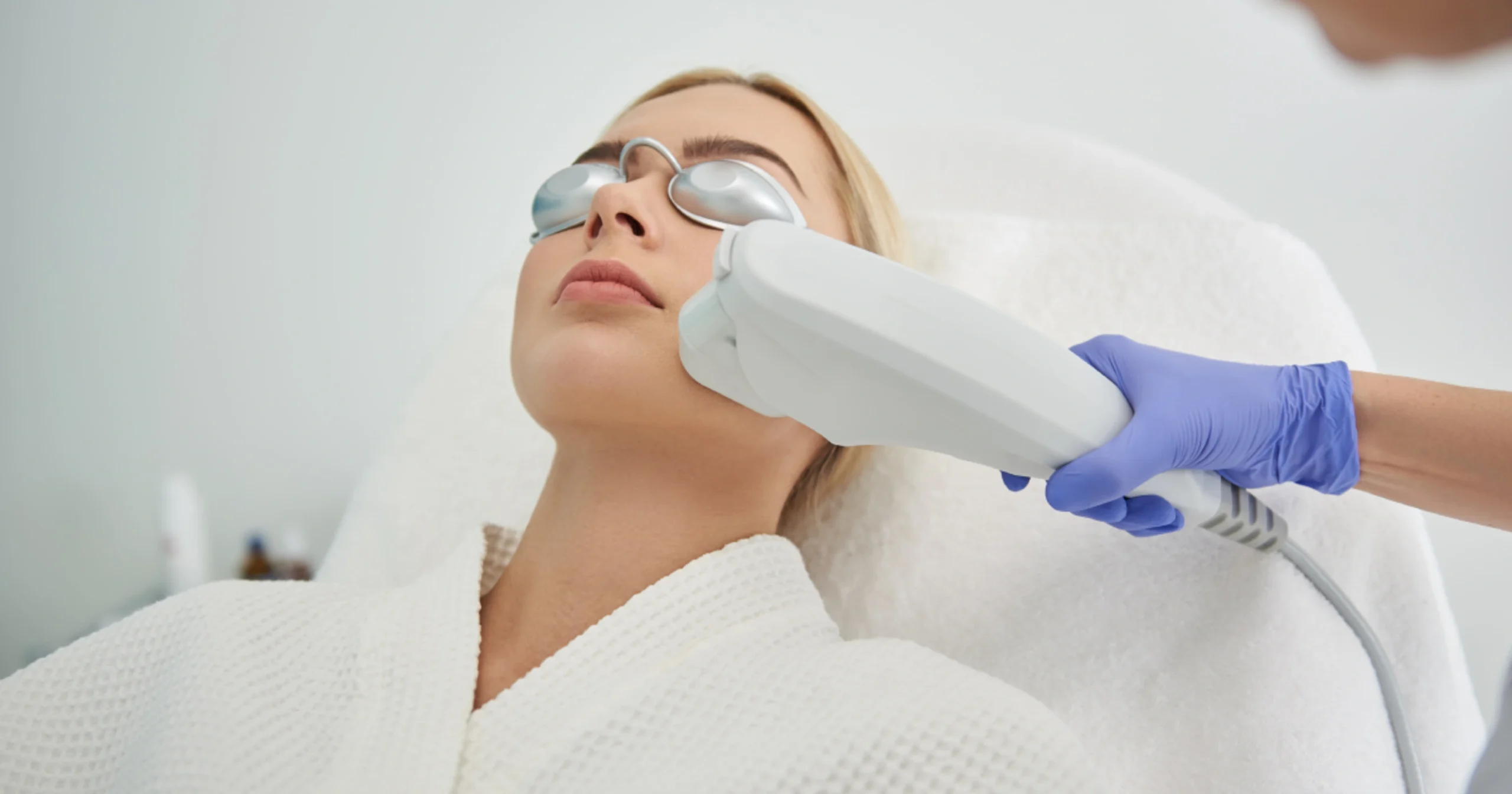 A young woman receives a Moxi laser treatment from a professional in Stillwater, OK
